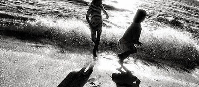 Fotografía de dos niñas jugando en la orilla del mar